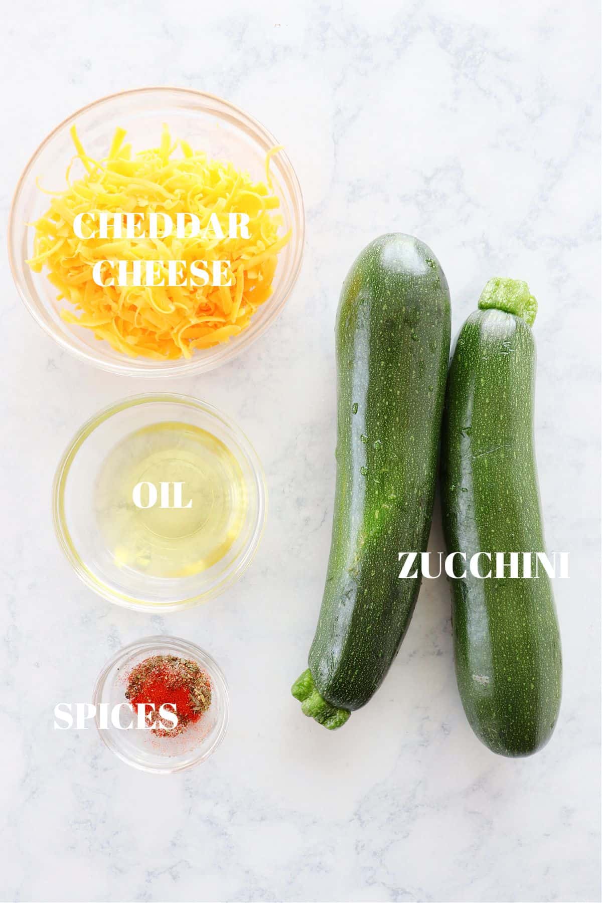 Ingredients for baked zucchini on a marble board.