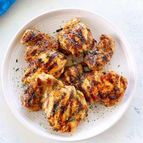 Grilled chicken thighs on a plate.