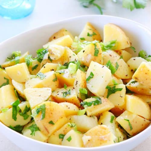 Potato salad in a white bowl.