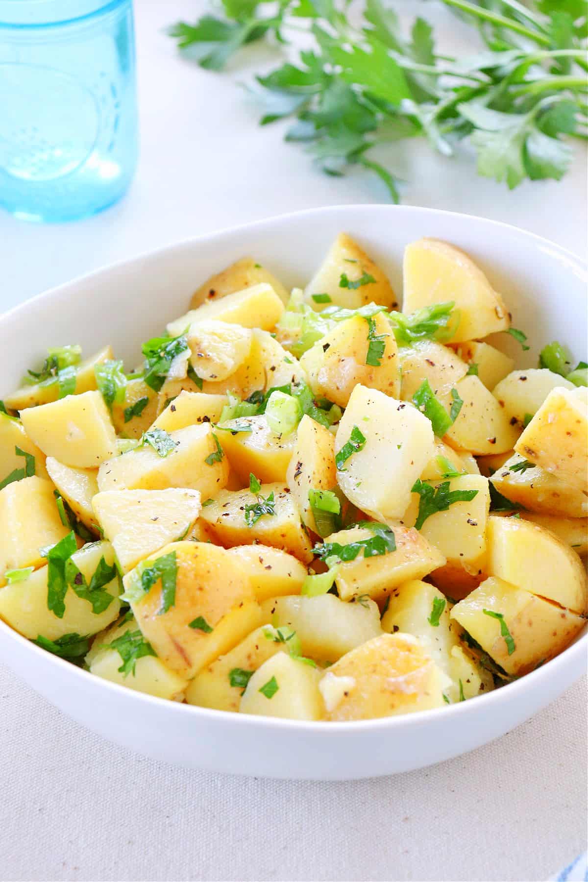 Potato salad in a white bowl.