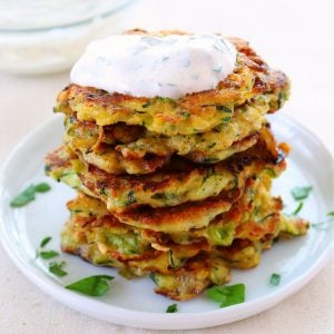 Stack of zucchini fritters on a plate.