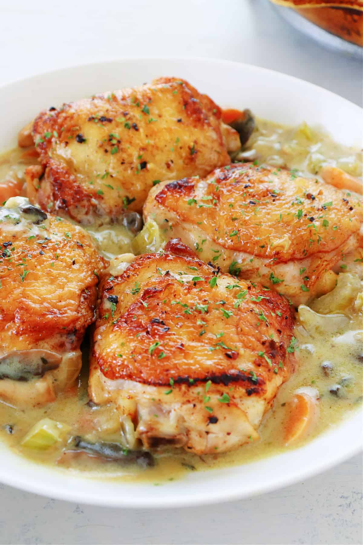 Chicken thighs with sauce in a bowl.