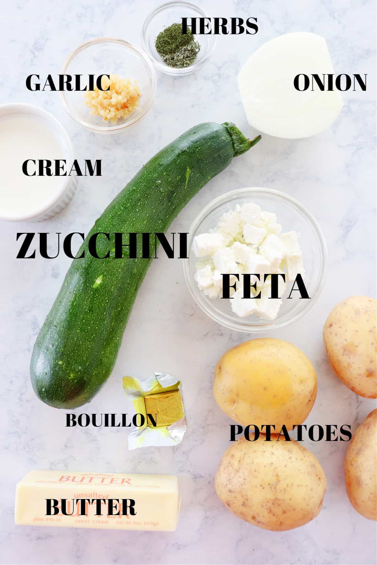 Ingredients for zucchini soup on a marble board.