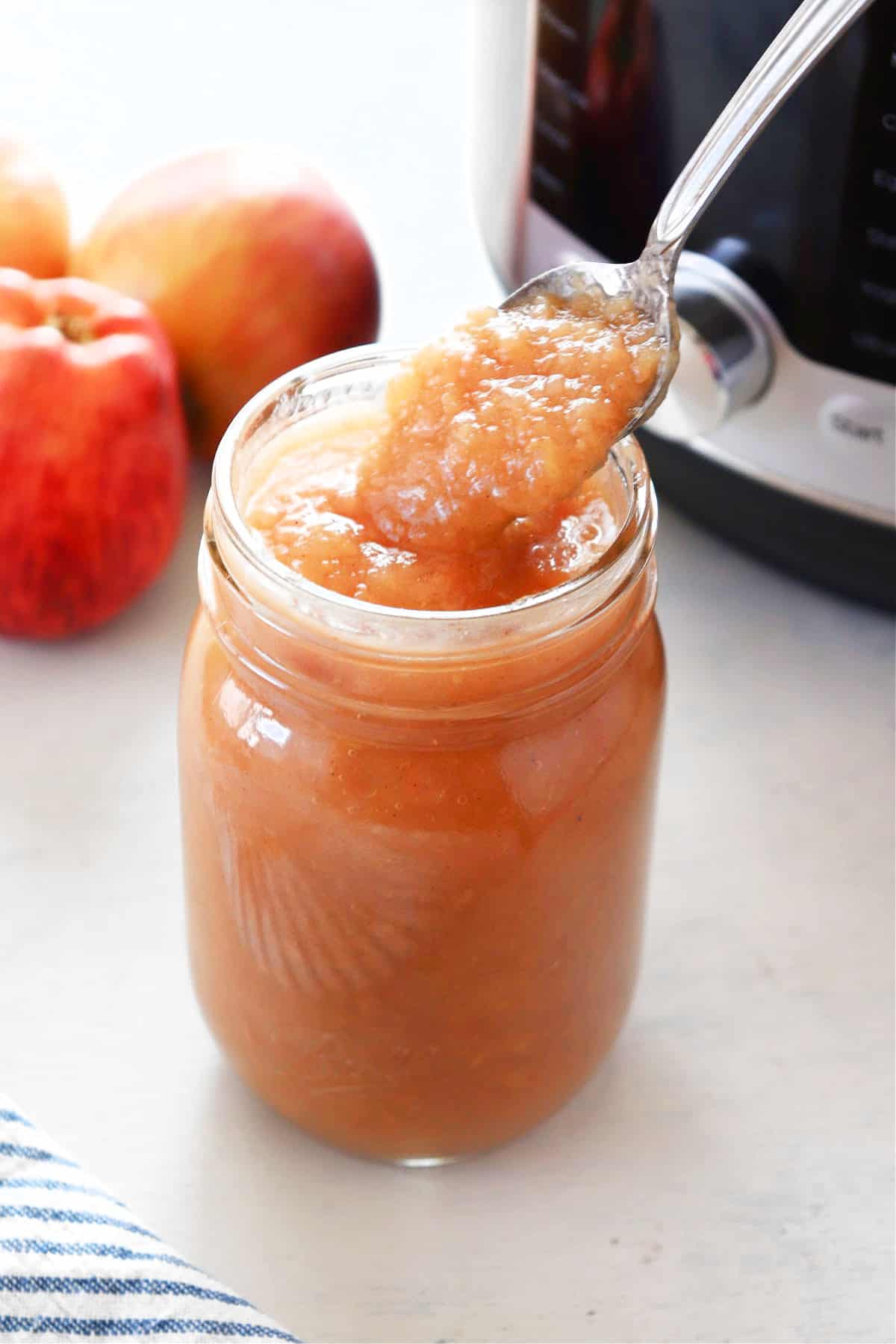 Applesauce in glass jar next to Instant Pot.