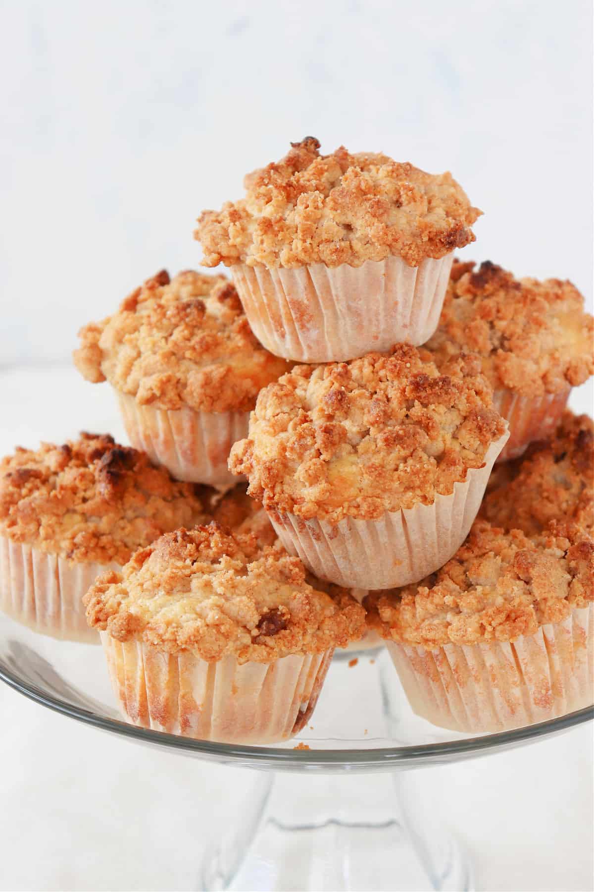 Apple crumb muffins on a cake stand.