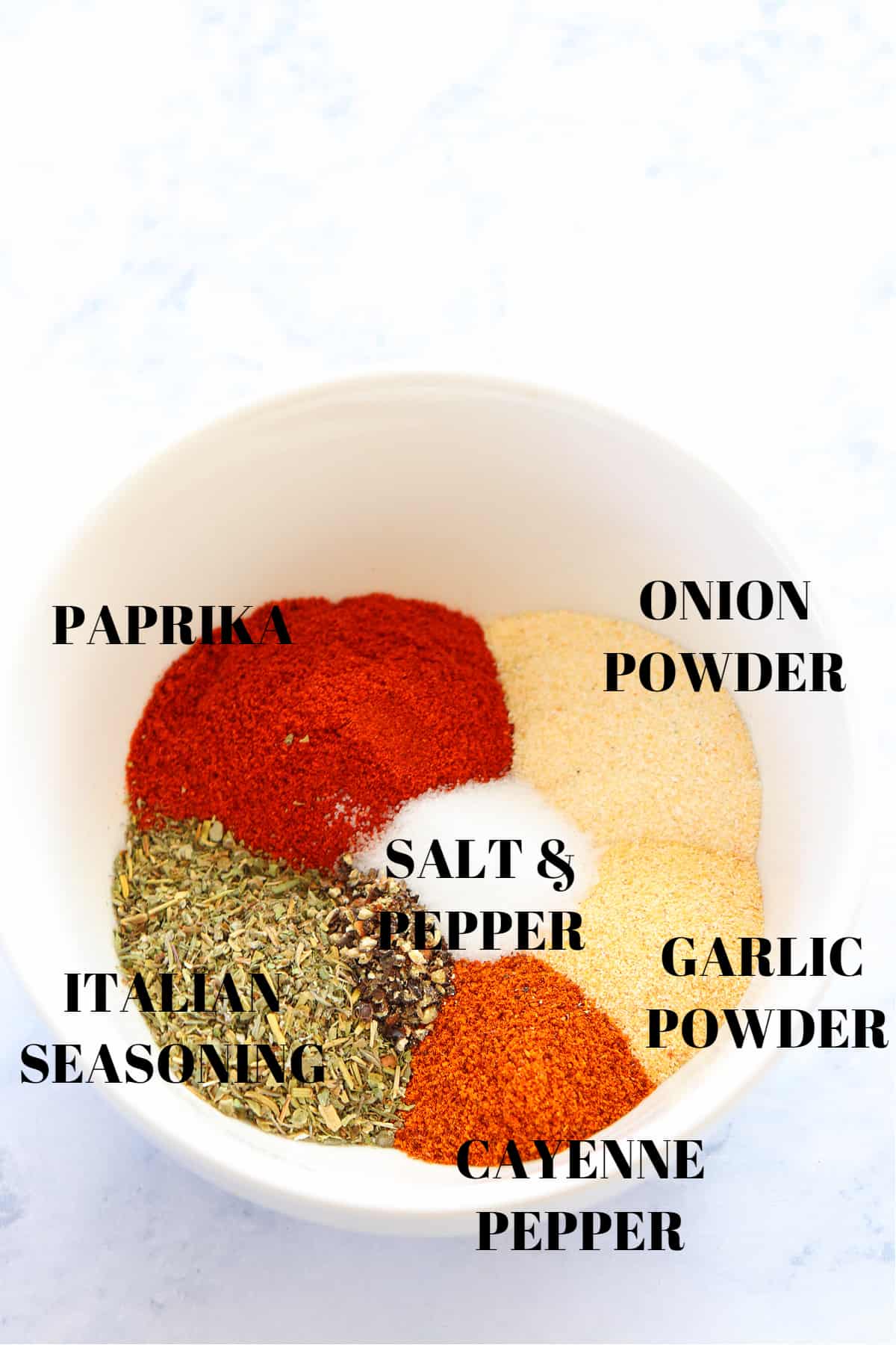 Spices for the seasoning mix in a white bowl.