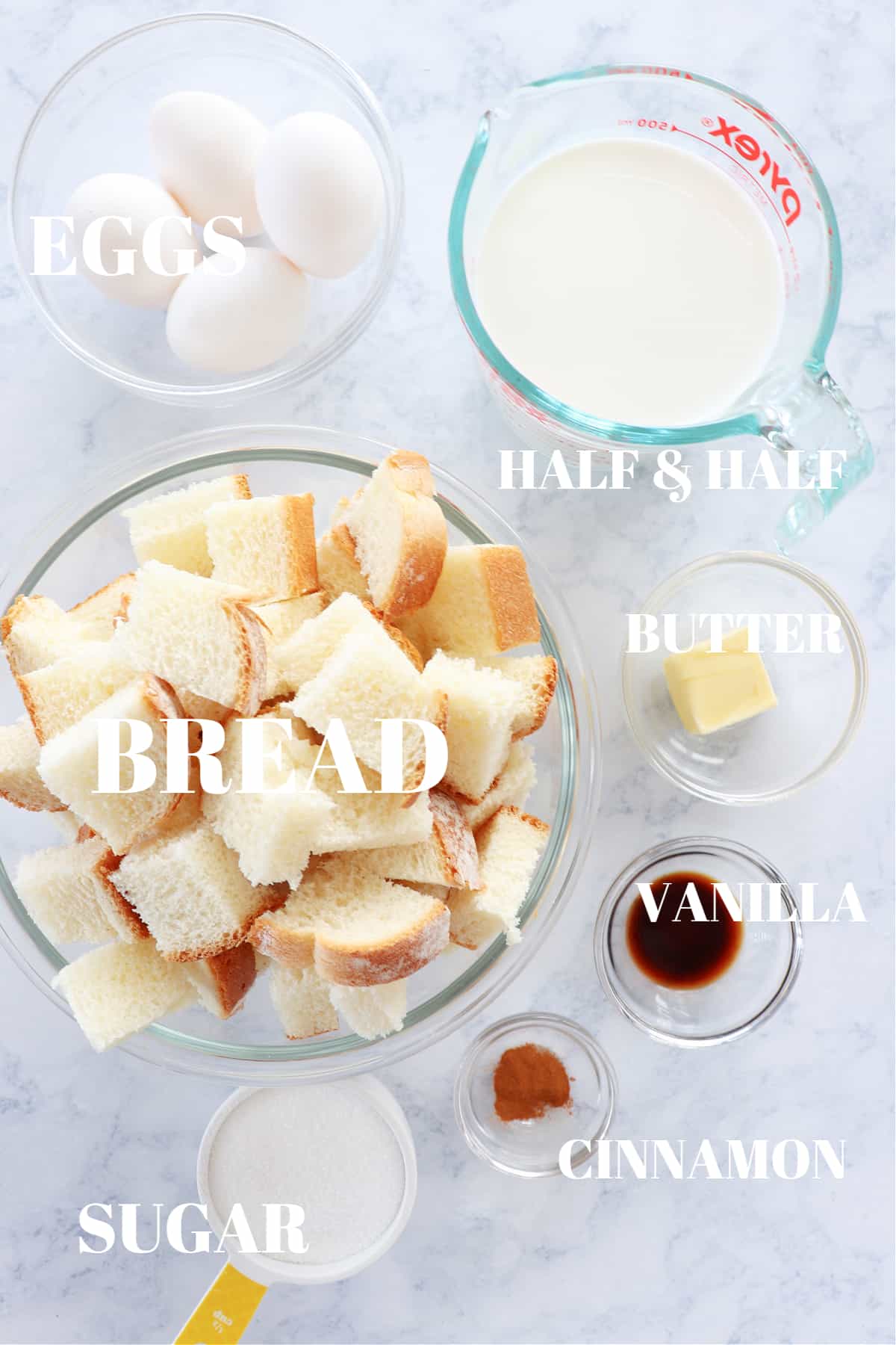 Ingredients for bread pudding on a marble board.