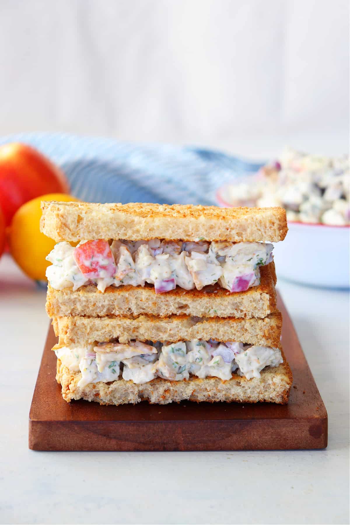 Sandwich with turkey salad on cutting board.