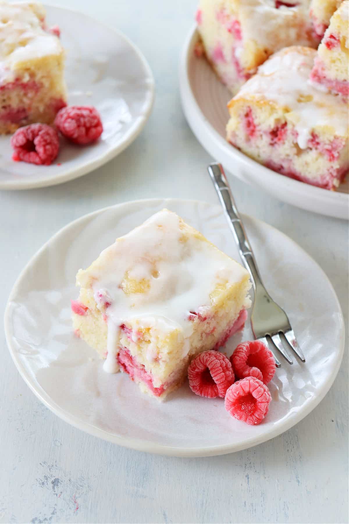 Slices of raspberry cake on dessert plates.