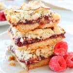 Raspberry bars stacked on a plate.