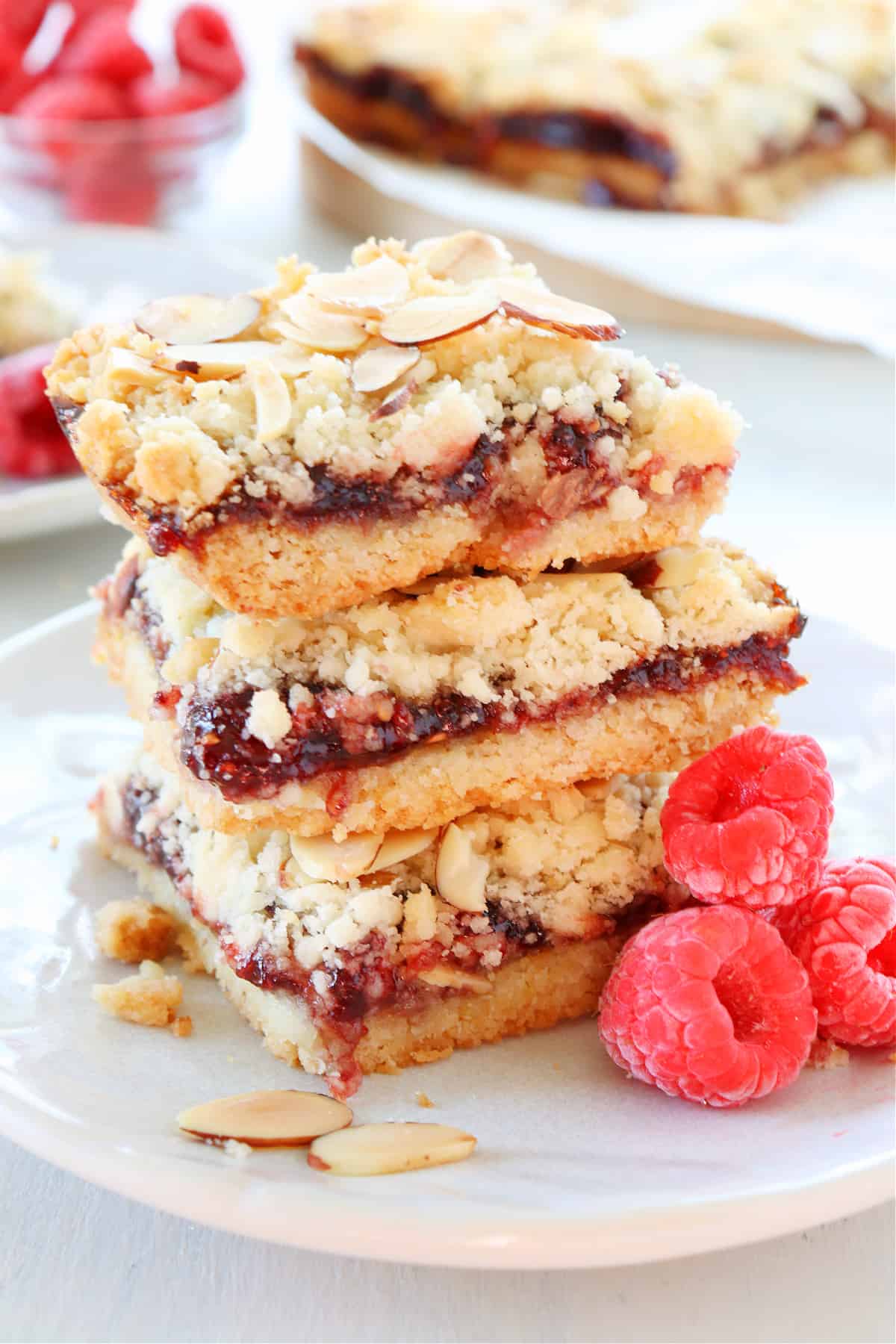 Raspberry bars stacked on a plate.