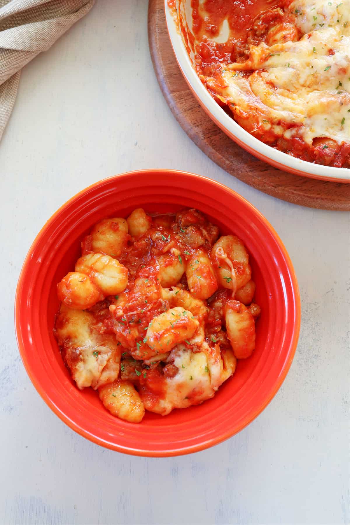 Gnocchi with sauce in an orange bowl.