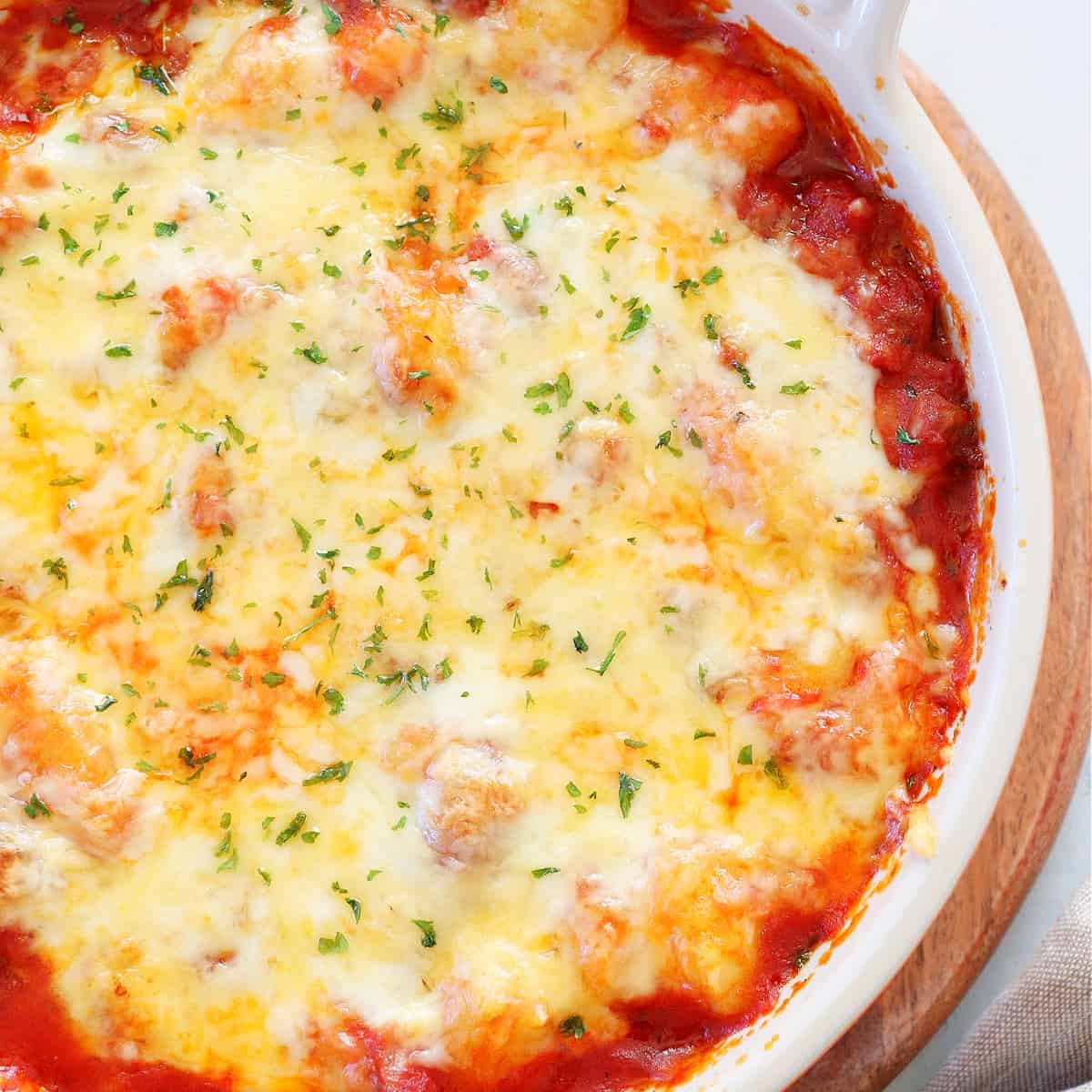 Cheesy top on baked gnocchi in dish.