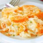 A serving of cheesy scalloped potatoes on a plate.