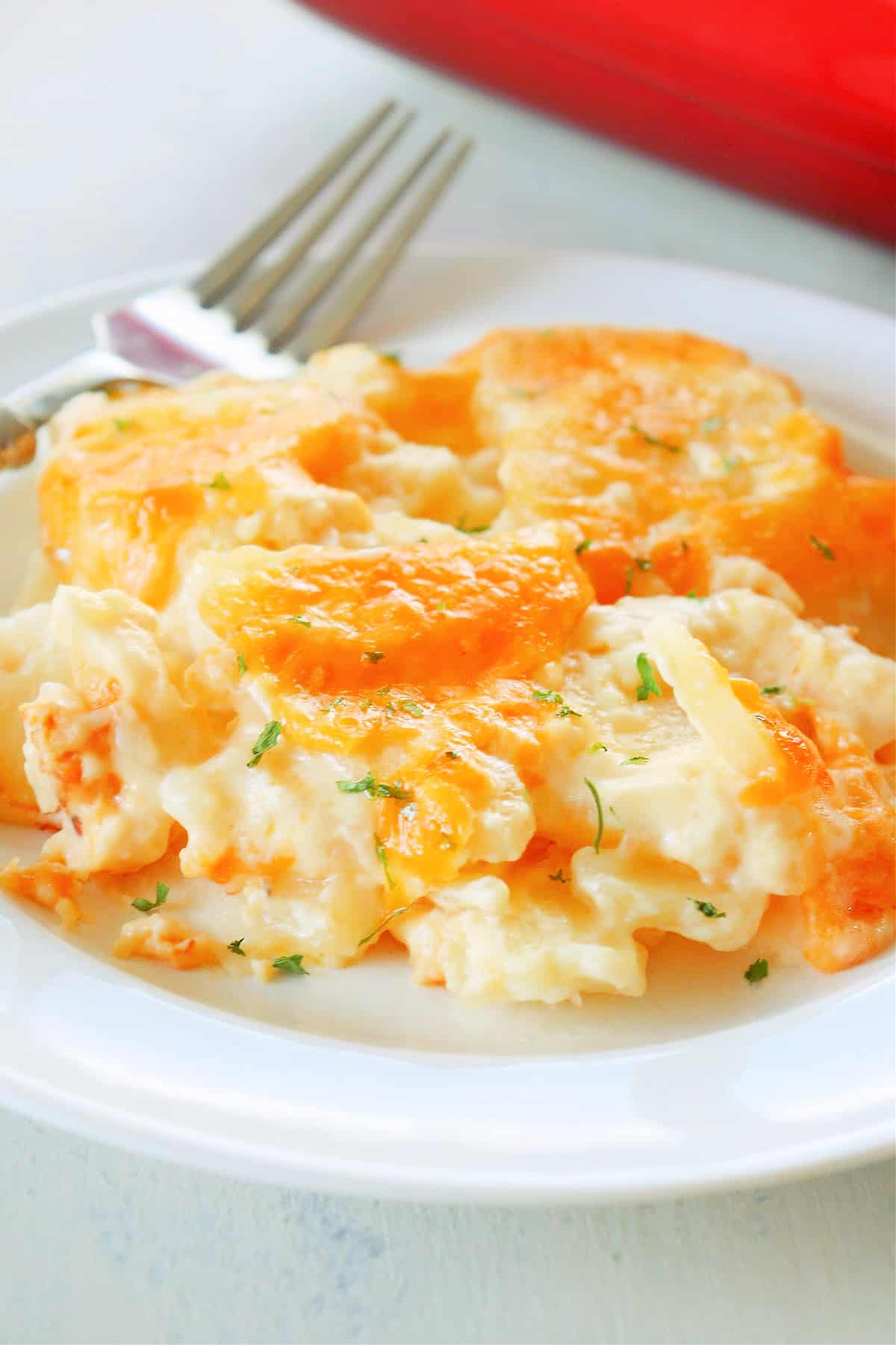 A serving of cheesy scalloped potatoes on a plate.