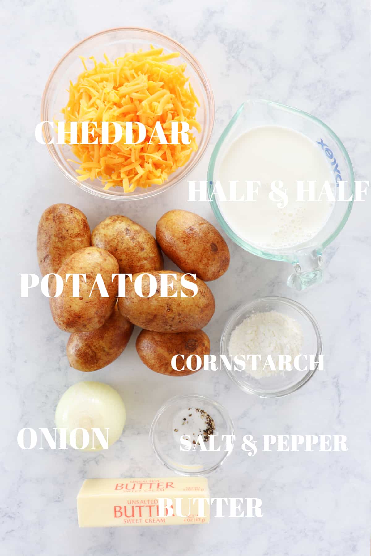 Ingredients for scalloped potatoes on a marble board.