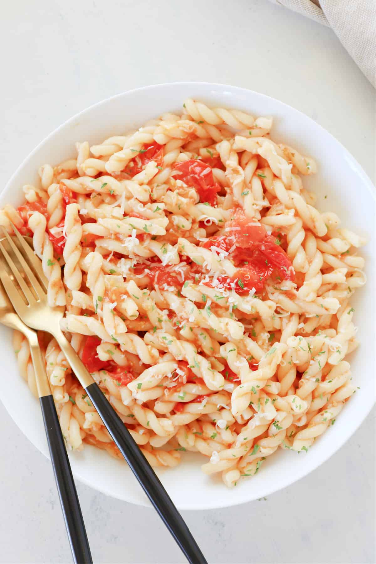 Pasta in a bowl with fork and spoon.