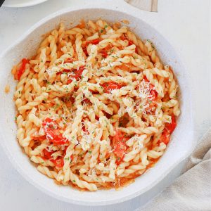 Pasta with tomatoes in a pan.