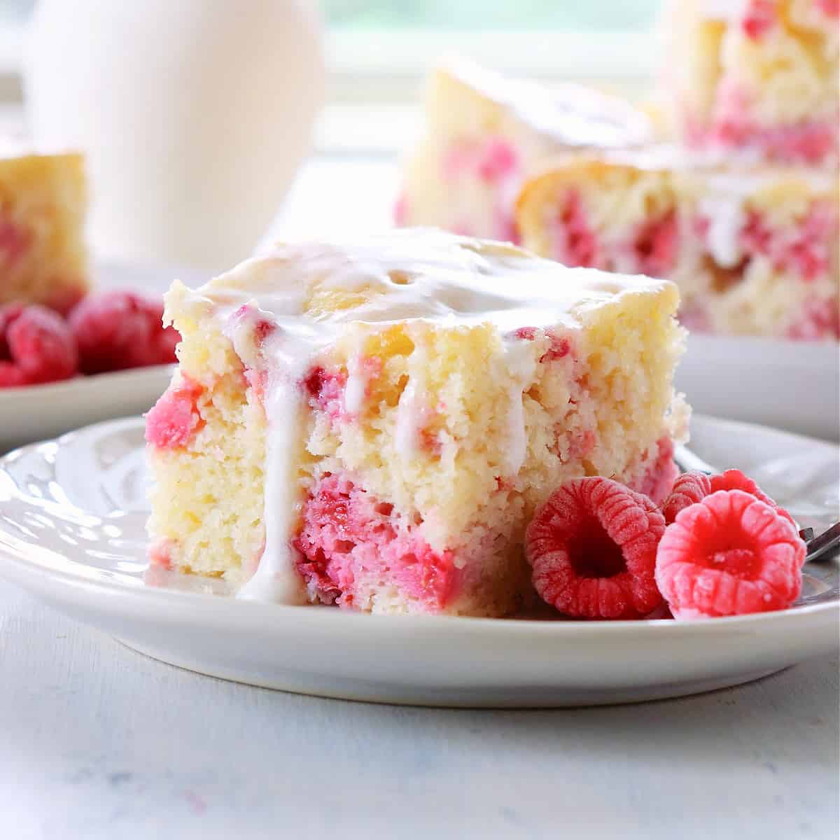 A slice of raspberry cake on a plate.