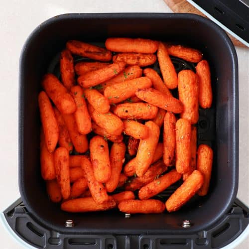 Baby carrots in the air fryer basket.
