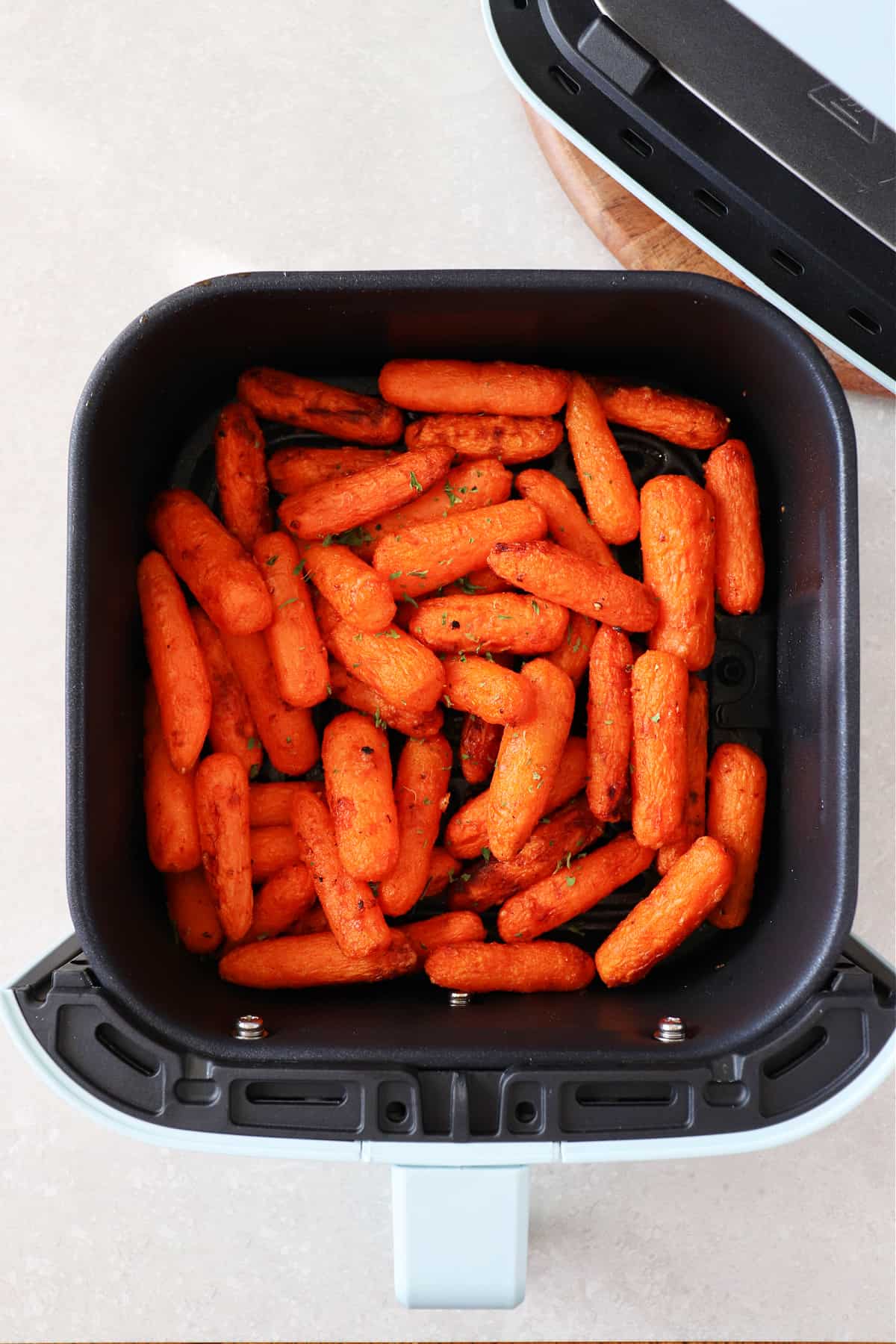 Baby carrots in the air fryer basket.