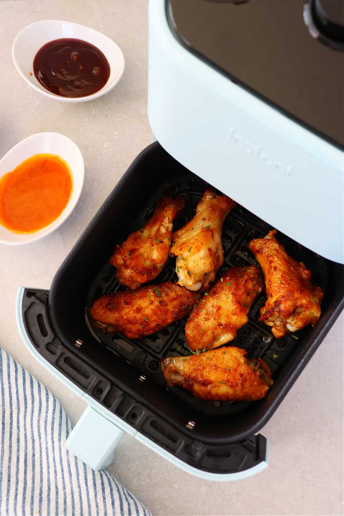 Chicken wings in the air fryer basket.