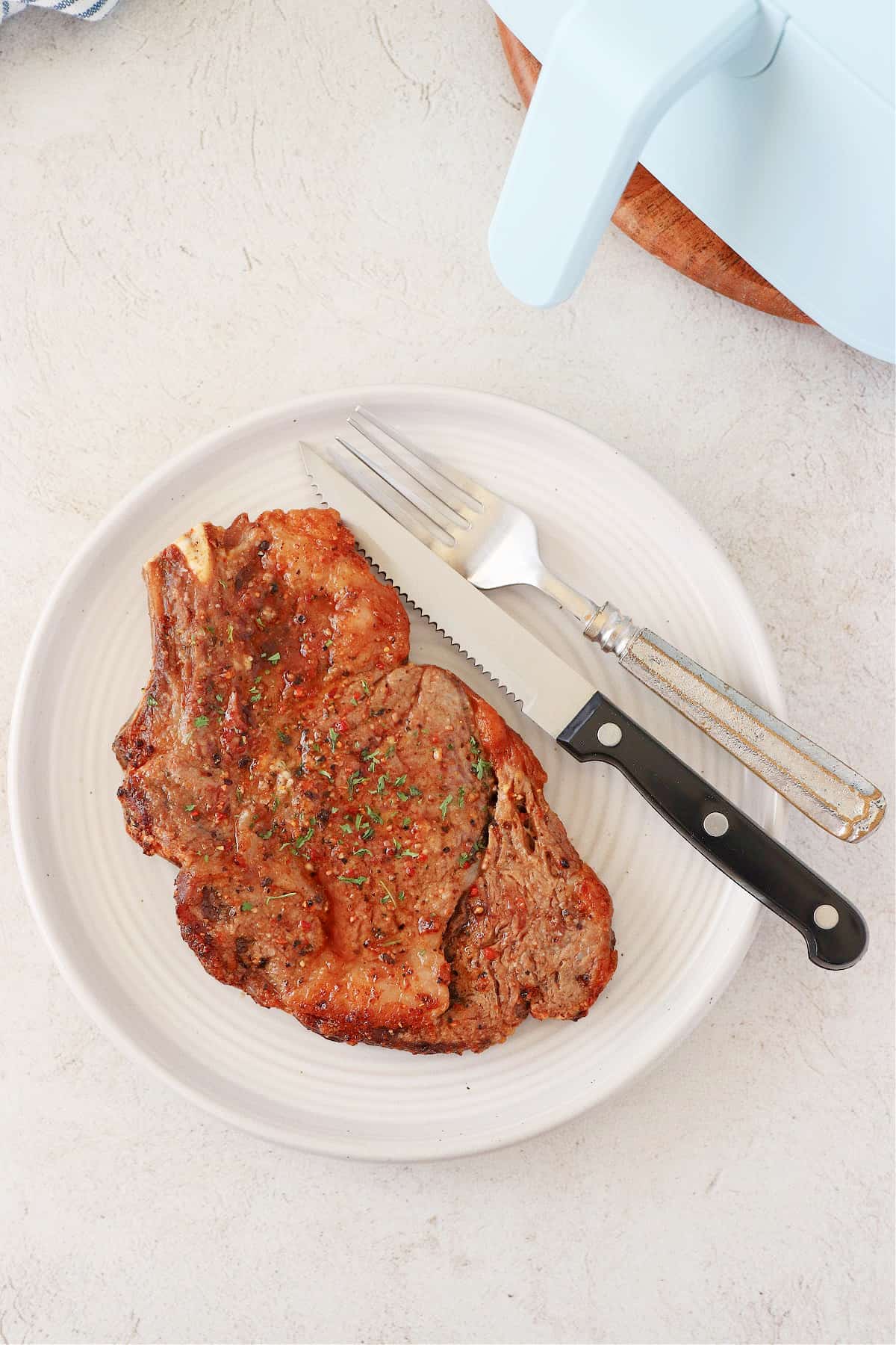 Cooked ribeye steak on a plate.