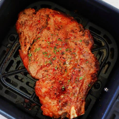 Steak in the air fryer basket.