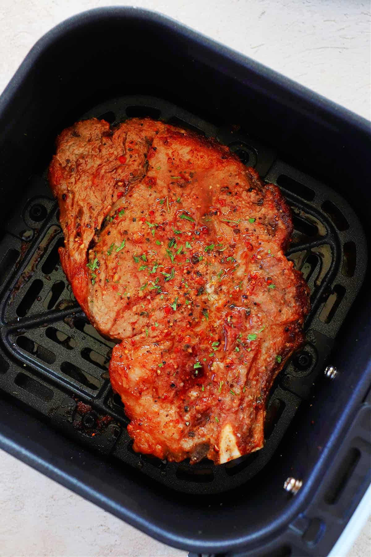 Steak in the air fryer basket.