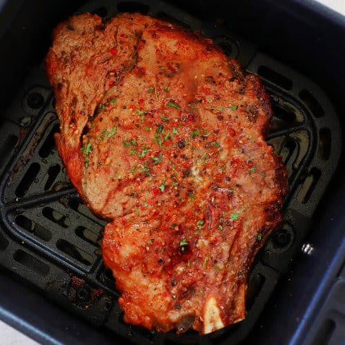 Steak in the basket of an air fryer.