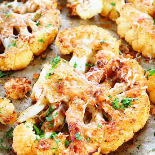 Cauliflower steaks on a baking sheet.