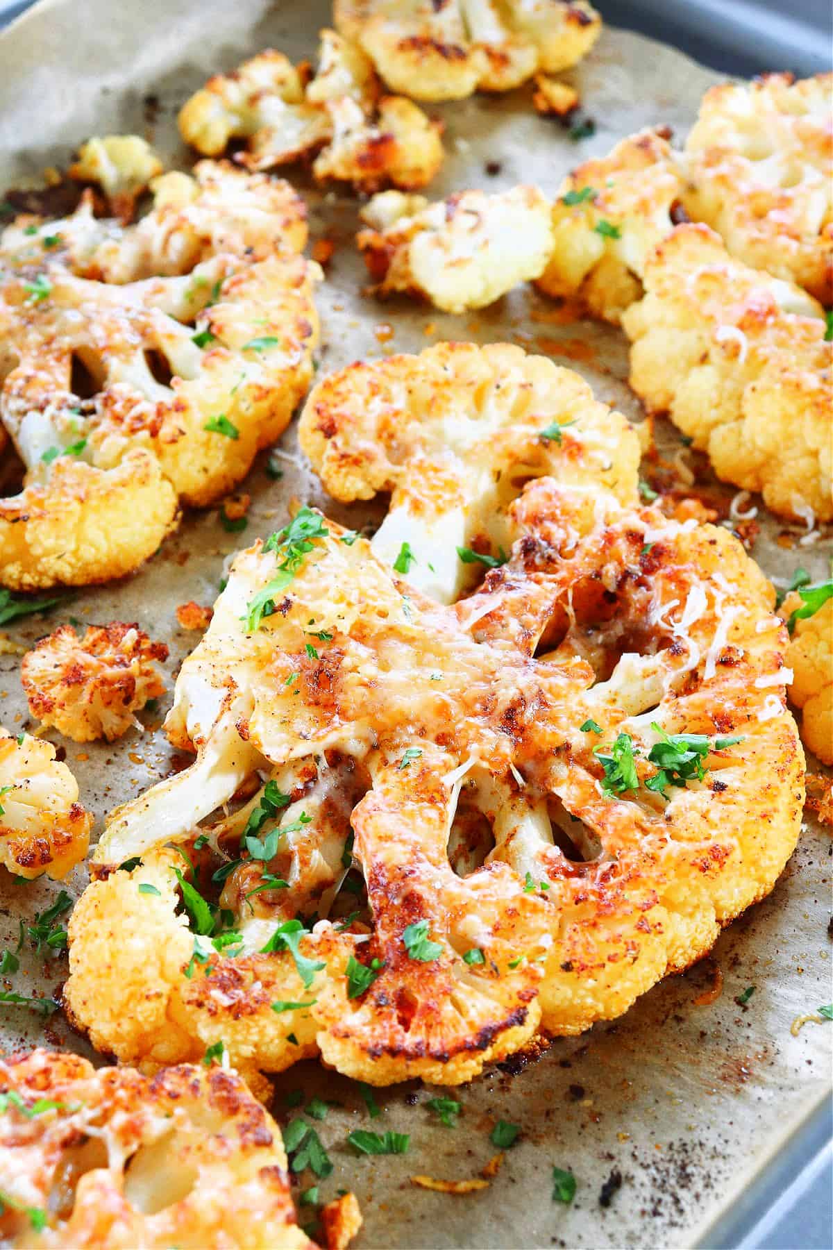 Cauliflower steaks on a baking sheet.