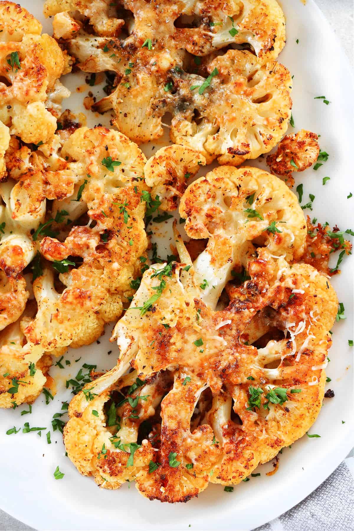 Roasted cauliflower steaks on a serving platter.