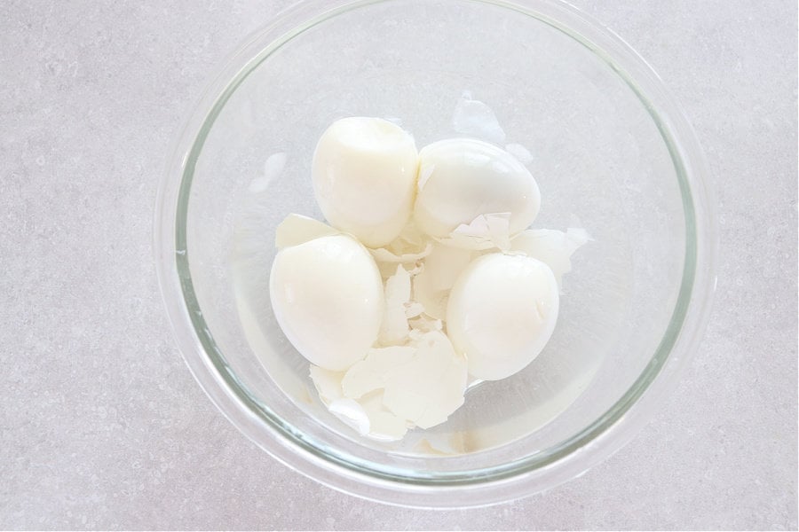 Peeled eggs in a glass with water.