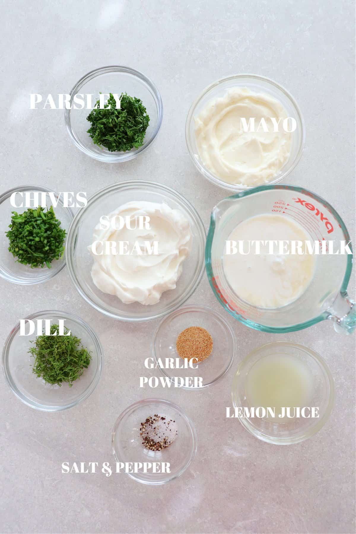 Ingredients for ranch dressing on a gray board.