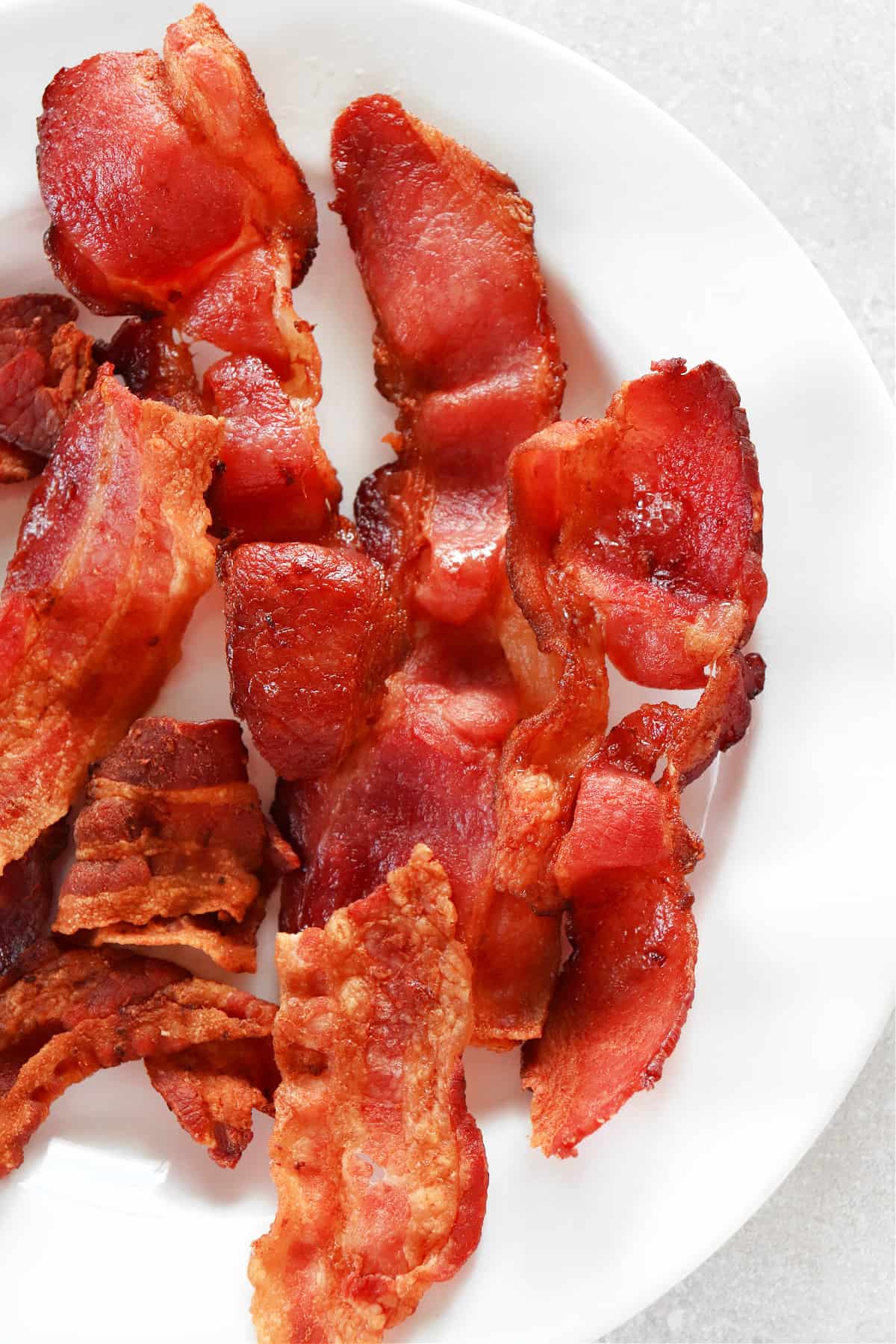 Cooked bacon on white plate.