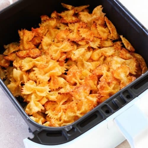 Fried pasta in air fryer basket.