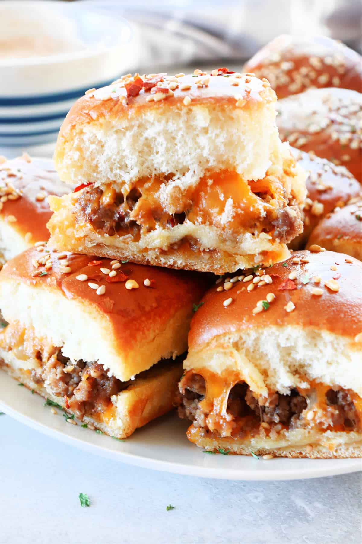 Cheeseburger sliders on a white plate.