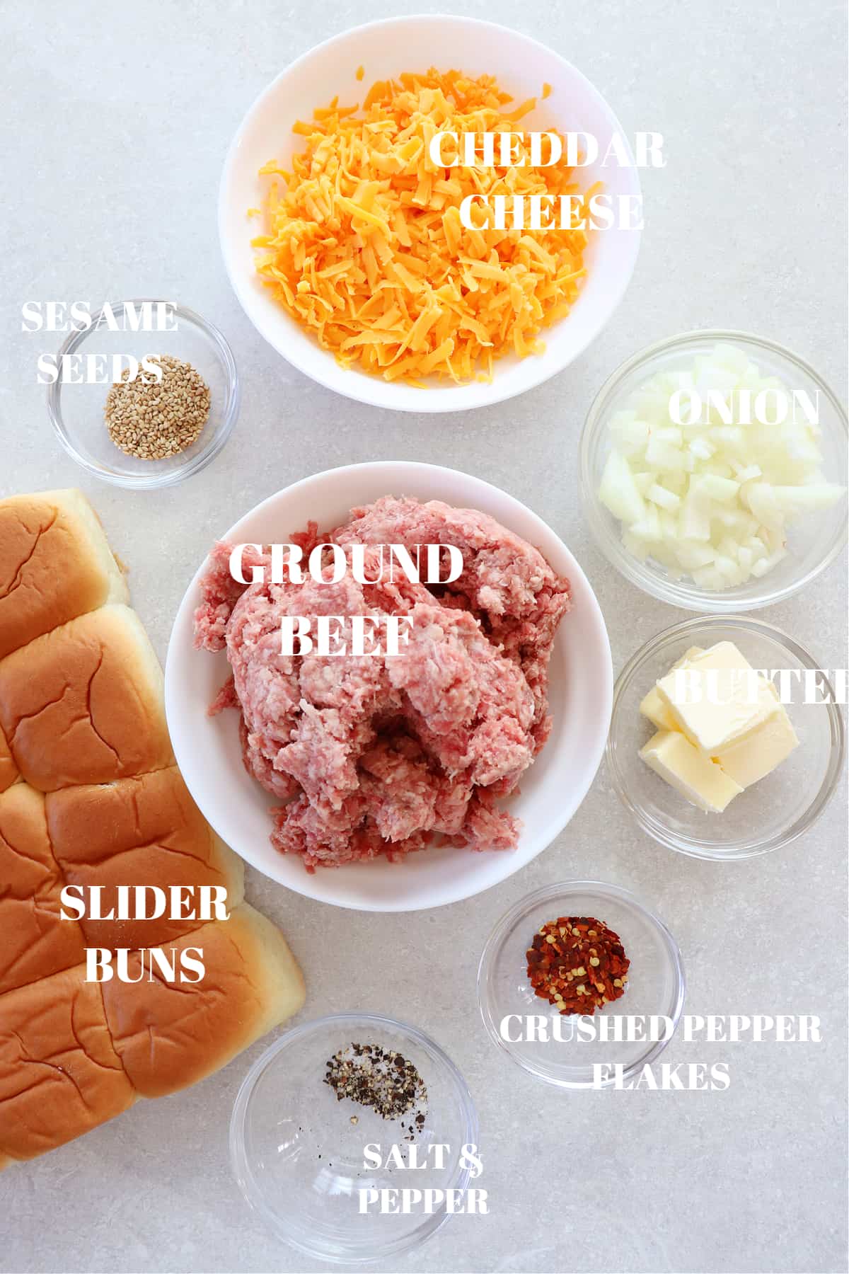 Ingredients for cheeseburger sliders on a board.