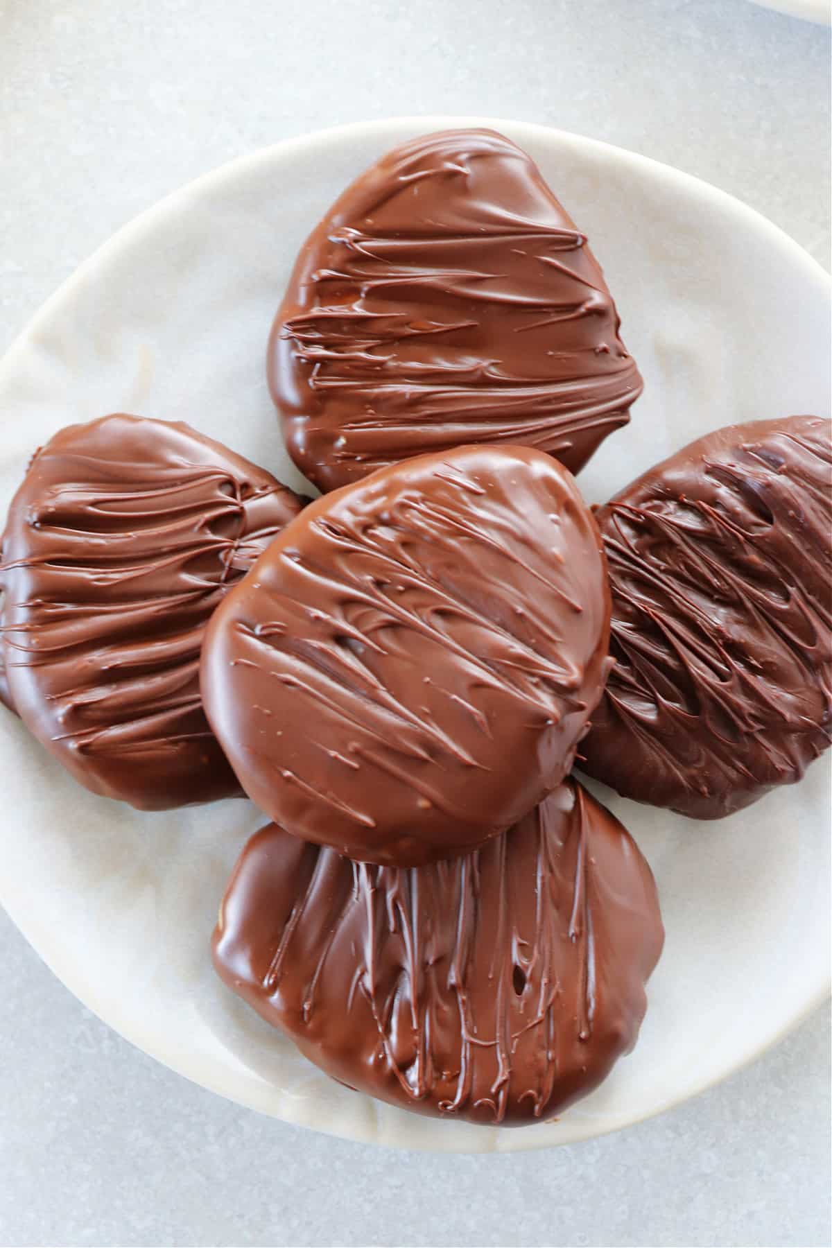 Chocolate covered peanut butter eggs on a cream plate.