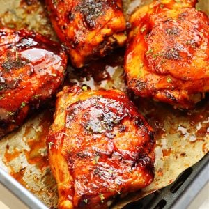 BBQ chicken thighs in the air fryer basket.