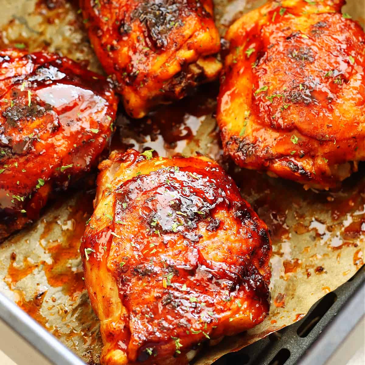 BBQ chicken thighs in the air fryer basket.