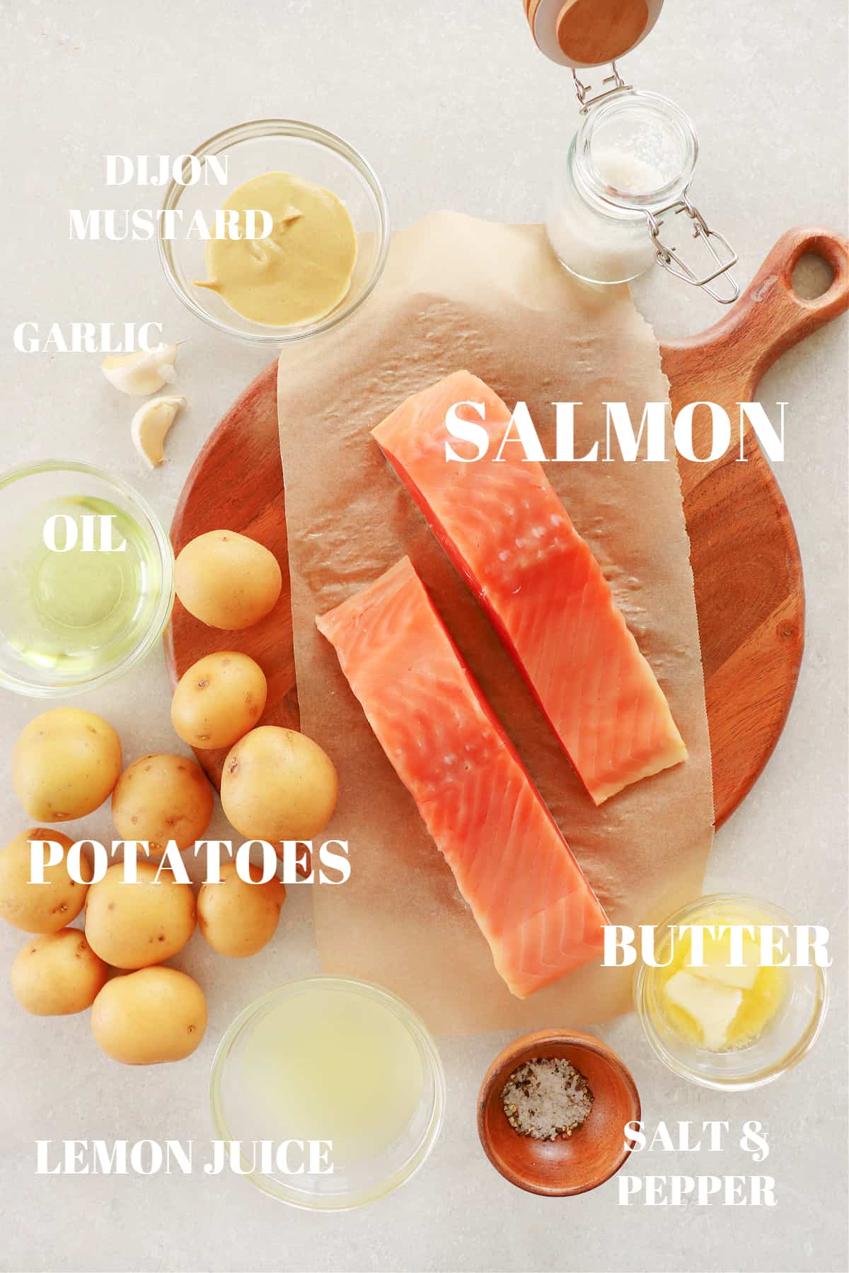 Ingredients for salmon and potatoes on a round wooden board.