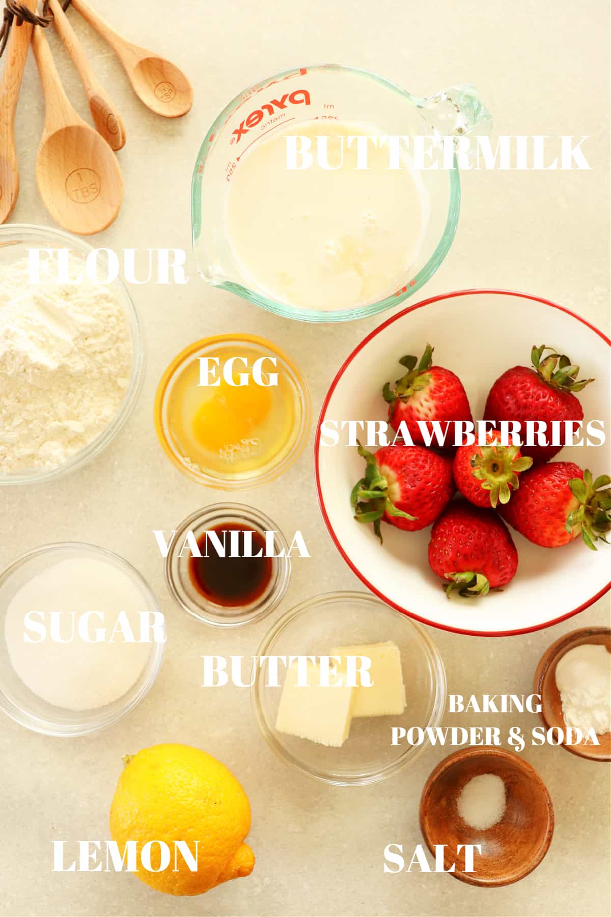 All ingredients for strawberry pancakes on a gray board.