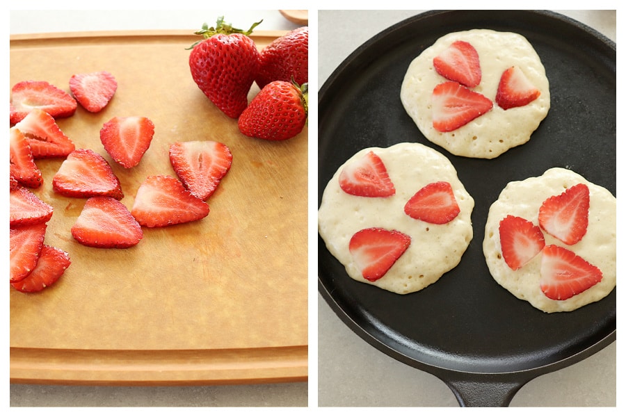 Sliced strawberries on a cutting board and on pancake batter.