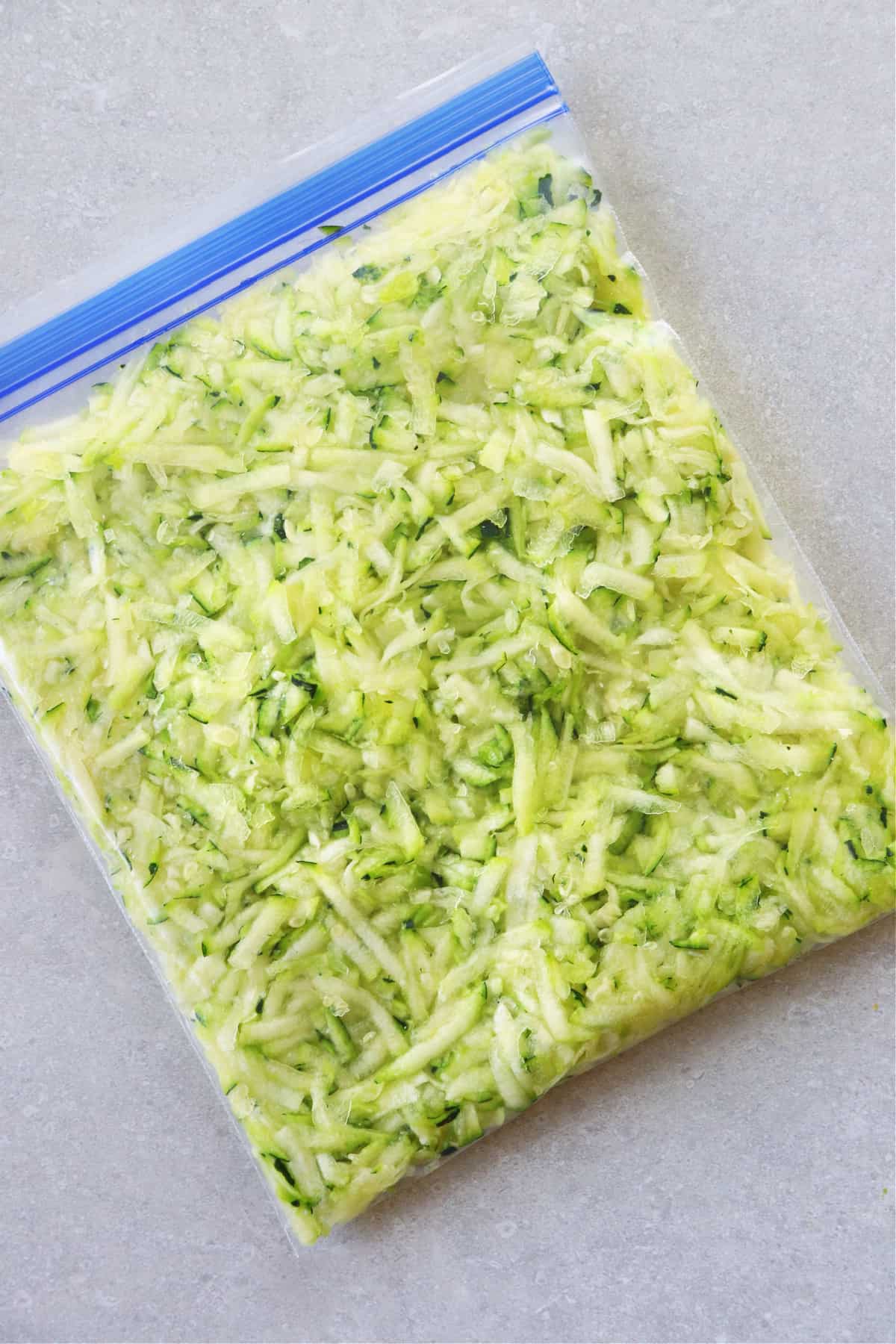 Shredded zucchini in a freezer bag.