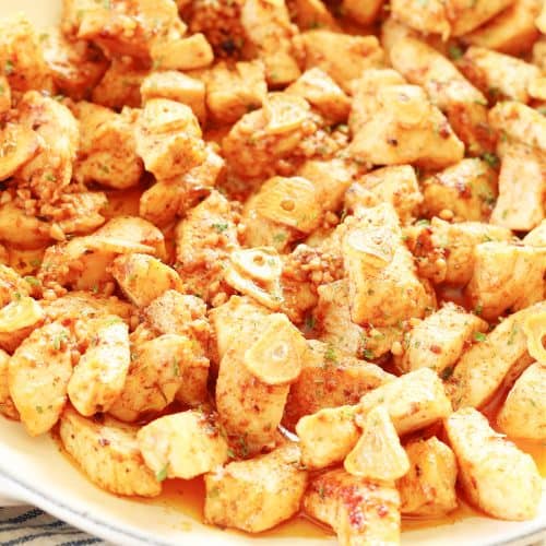 Cooked chicken in a pan with butter sauce.