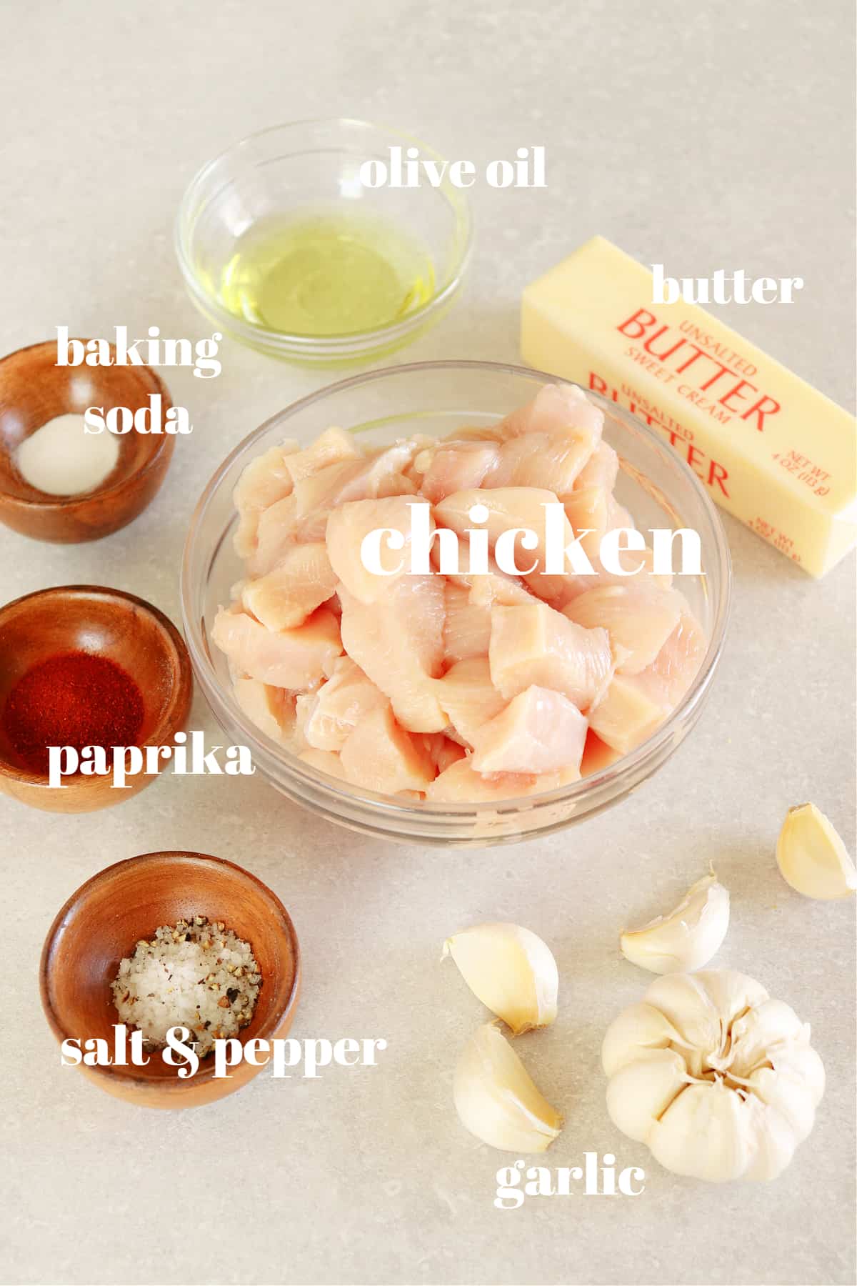 Ingredients for garlic butter chicken recipe on a gray board.