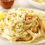 A serving of fettuccine with zucchini sauce on a cream plate.