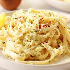 Close up of a serving of creamy zucchini pasta on a plate.